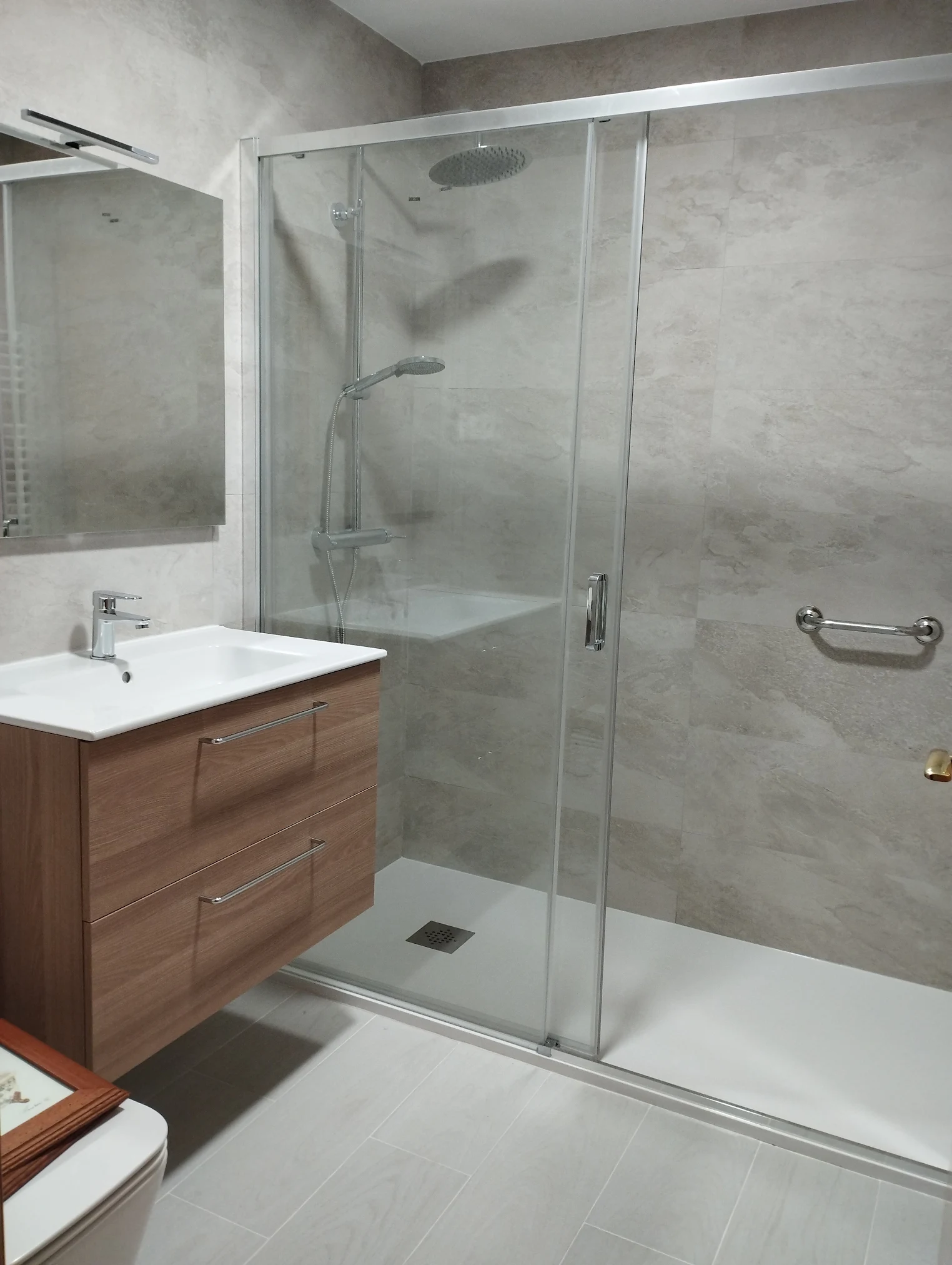 Baño moderno con plato de ducha y mampara instalado por Gracias Paco